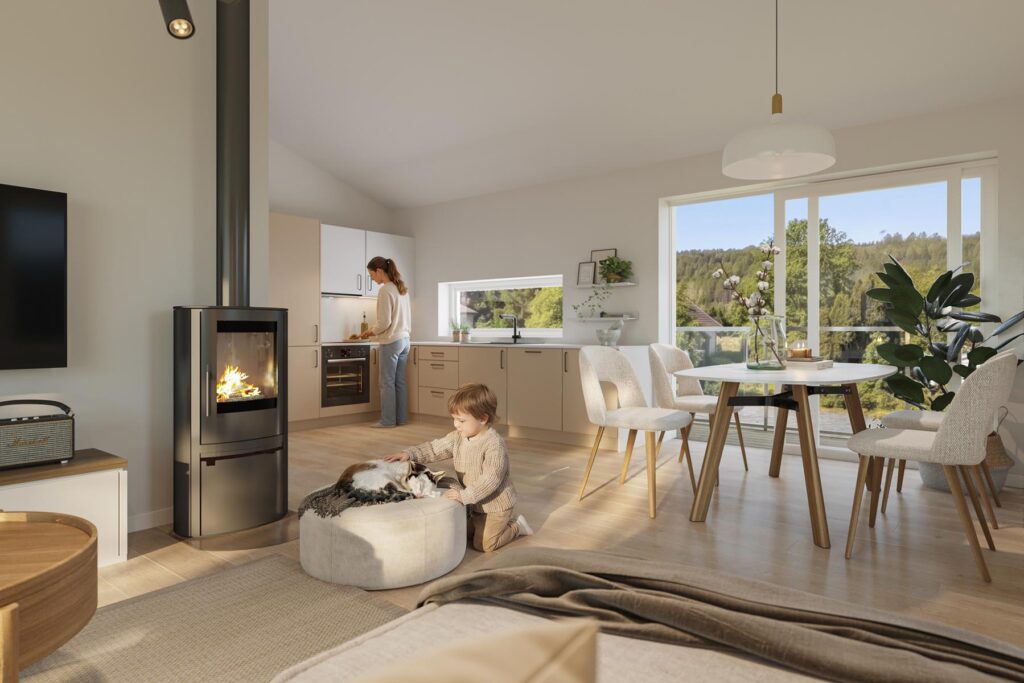 Den koselige, moderne stuen og kjøkkenet i Sveitservillaen på Nordstrand har store vinduer. Et barn klapper en katt på en puff ved vedovnen, mens en voksen lager mat. Sollyset fremhever den lyse innredningen og grønne omgivelsene utenfor.